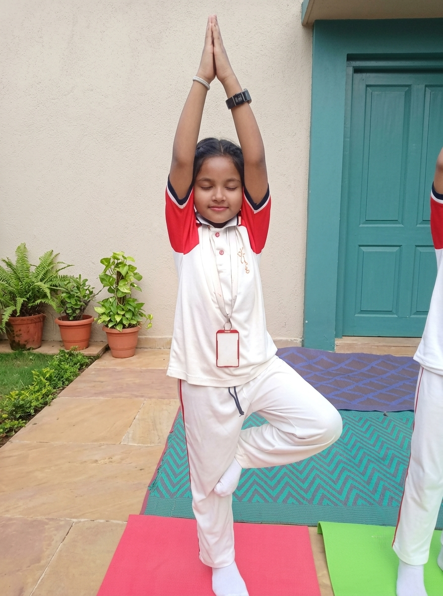 Young student gracefully practicing the tree pose during a Yoga session at Green Point School
